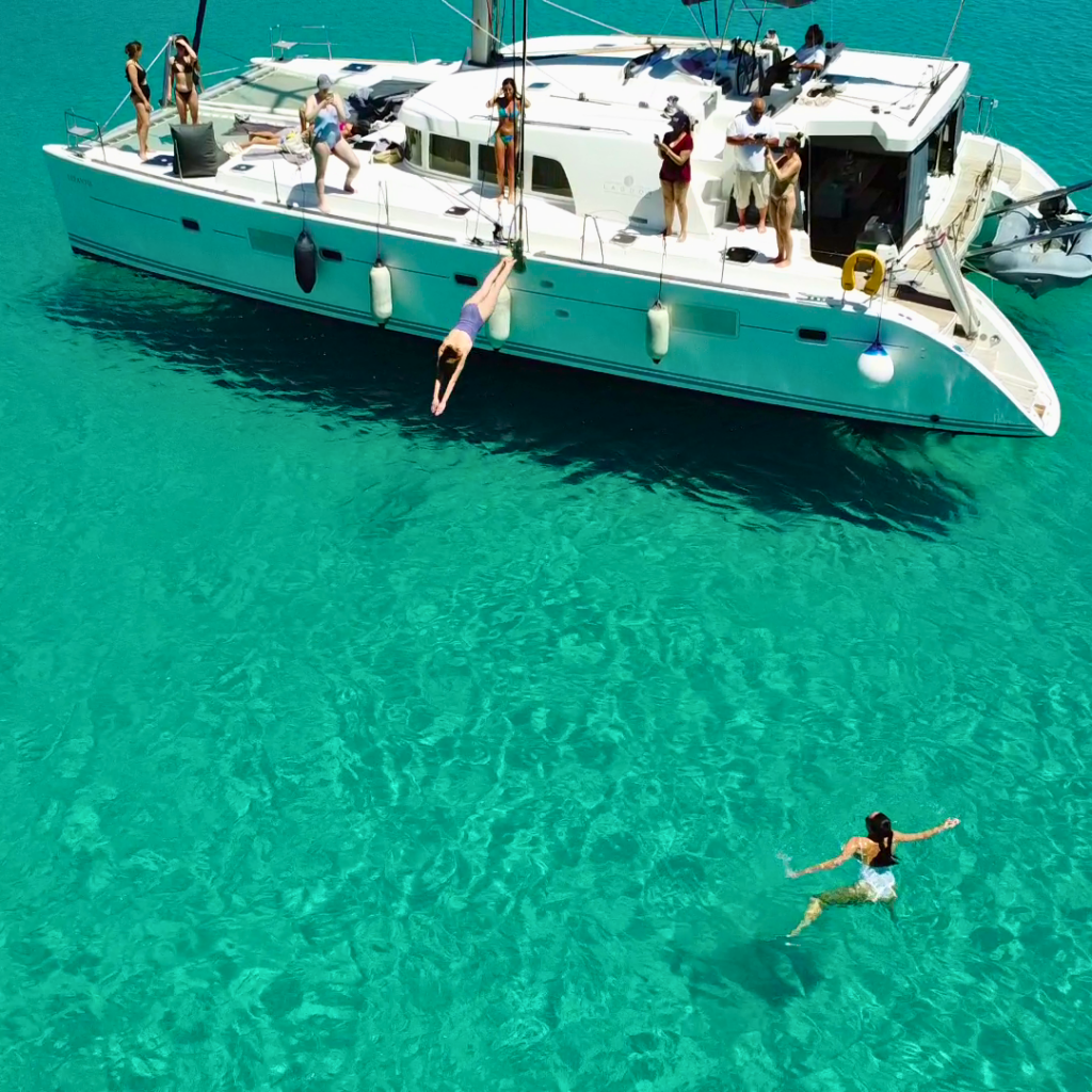 A guest diving into the sea while her friends are taking photos